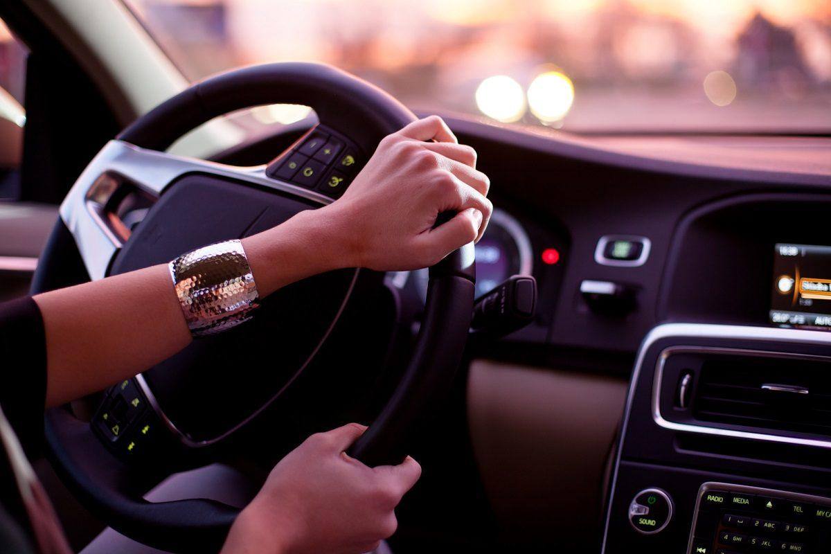 Woman's hand on steering wheel during sunset drive